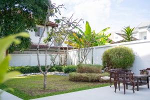 a garden with tables and chairs in front of a building at Singharaj Boutique Hotel in Chiang Mai