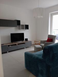a living room with a couch and a tv at Maresol apartment in Carrara