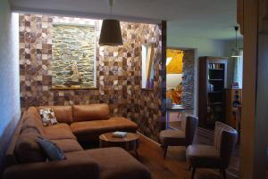 a living room with a couch and a stone wall at Ard'envie vakantiewoning - holiday home in Houffalize