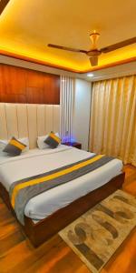 a bedroom with a large bed with a yellow ceiling at Hotel The Rich Grand Agra in Agra