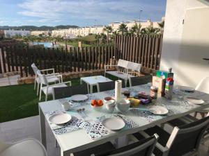 una mesa blanca con platos en un patio en Premium Holidays - Modern holiday home with pool nearby Vistabella Golf, en Orihuela
