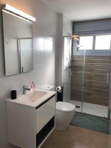 uma casa de banho com um lavatório, um WC e um espelho. em Premium Holidays - Modern holiday home with pool nearby Vistabella Golf em Orihuela