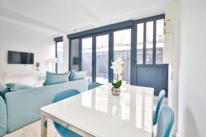 ein Wohnzimmer mit einem weißen Tisch und blauen Stühlen in der Unterkunft Beautiful Appartment 6 Peoples in Montrouge