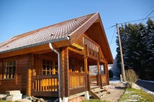 eine große Holzhütte mit einer großen Veranda in der Unterkunft véritable chalet finlandais in Basse-sur-le-Rupt