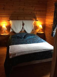 ein Schlafzimmer mit einem Bett mit zwei Lampen auf beiden Seiten in der Unterkunft véritable chalet finlandais in Basse-sur-le-Rupt