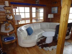a living room with a white couch and a table at véritable chalet finlandais in Basse-sur-le-Rupt