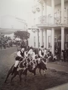 een groep mensen die paardrijden voor een gebouw bij Mariano IV Palace Hotel in Oristano