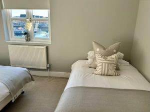 a bedroom with a bed with pillows and a window at Entire Town House In Liverpool Marina in Liverpool