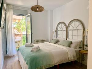 a bedroom with a large bed with towels on it at Dolce Terrassa 25 min Barcelona and Beach in Terrassa