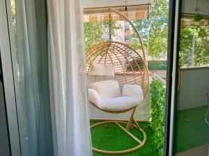 a wicker chair sitting on a porch at Dolce Terrassa 25 min Barcelona and Beach in Terrassa