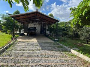 バンガロールにあるSai Farm House - Abode of peaceの屋根の建物につながる石畳の通路