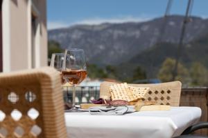 una tavola con un bicchiere di vino e un piatto di cibo di Hotel Alla Corte SPA & Wellness Relax a Bassano del Grappa