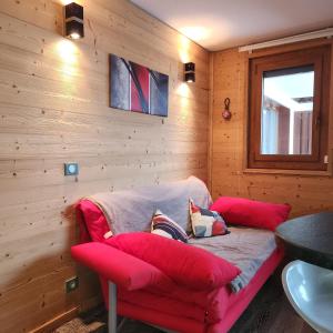 a living room with a red couch and a window at Terrasses du Morel - A17 - Appart 5 pers in Doucy