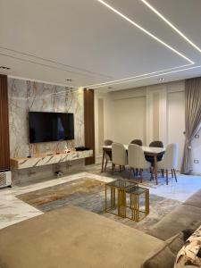 شقه فندقيه مستقله بالشيخ زايد في Sheikh Zayed: غرفة معيشة مع طاولة وتلفزيون