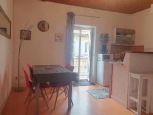 a kitchen with a table and chairs in a room at Appartement meublé centre ville NYONS in Nyons