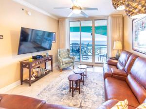 a living room with a couch and a flat screen tv at Azure #610 - Jack's Beach House - Top Floor Luxury in Fort Walton Beach