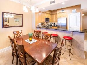 a kitchen with a wooden table and chairs at Azure #610 - Jack's Beach House - Top Floor Luxury in Fort Walton Beach