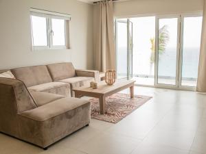 a living room with a couch and a table at Seaview appartments boca sami in Dorp Sint Michiel