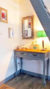een tafel met een lamp en een spiegel aan een muur bij Apartament Old England in Żywiec