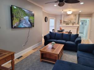 - un salon avec un canapé bleu et une télévision murale dans l'établissement Two level full house in downtown, à Buffalo