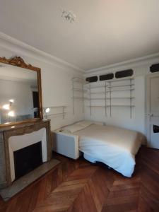1 dormitorio con cama, espejo y TV en Chambre spacieuse - Trocadéro, en París