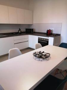 uma cozinha com uma mesa branca com cadeiras e um balcão em Maresol apartment em Carrara