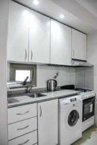 cocina con armarios blancos y lavadora en Dpto 1 dormitorio con Cochera Moderno y Luminoso en Santa Fe