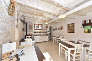 un restaurante con mesas blancas y sillas blancas en Il Nido dei Gufi Bed and Breakfast, en Toscolano Maderno