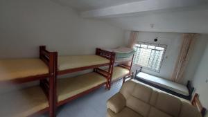 瓜拉圖巴的住宿－Pousada Maringá，带三张双层床和一张沙发的房间