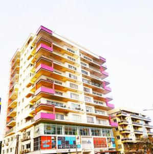 d'un grand immeuble avec balcon coloré. dans l'établissement Chambres meublées Avenue Cheikh Anta Diop, à Dakar