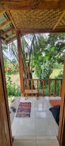 a screened in porch with a bench and a rug at Tetebatu Hostel Private Bungalow in Tetebatu