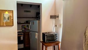 een keuken met een koelkast en een magnetron op een tafel bij Hospedaje Paraiso Frente al Rio in Santa Rosa de Calamuchita