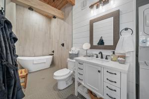 bagno con lavandino, servizi igienici e specchio di Whispering Pines - Lakeside a High Hill