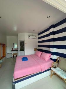 a bedroom with a large pink bed and a couch at Baancaptainhook pool kohlarn in Ko Larn