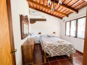 een slaapkamer met een bed en een spiegel bij Hospedaje Paraiso Frente al Rio in Santa Rosa de Calamuchita