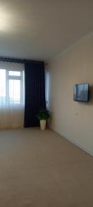 um quarto vazio com uma janela e um vaso de plantas em Квартира em Samarkand