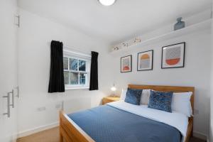 a bedroom with a blue and white bed and a window at King's Cross Penthouse by MoreThanStays in London