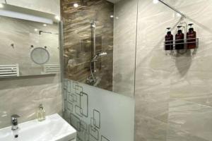 La salle de bains est pourvue d'un lavabo et d'une douche en verre. dans l'établissement Gemütliche Wohnung in Ottakring, à Vienne