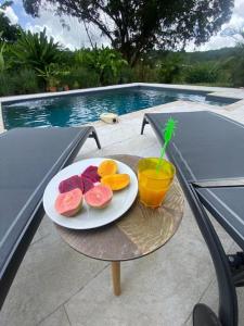 um prato de fruta numa mesa ao lado de uma piscina em Coquette villa avec piscine proche des plages em Sans Pareil