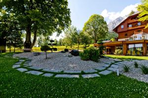 ogród z kamienną ścieżką przed budynkiem w obiekcie Ramsauhof w mieście Ramsau am Dachstein