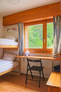 - une chambre avec des lits superposés, un bureau et une fenêtre dans l'établissement Kid-friendly studio near Ski Lifts, à Crans-Montana