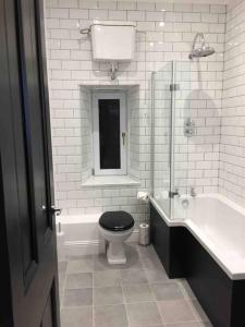 a bathroom with a toilet and a sink and a tub at Tarbert large, bright, 4 bedroom flat with harbour views in Tarbert +12 photos
