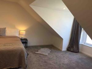 a attic room with a bed and a window at Tarbert large, bright, 4 bedroom flat with harbour views in Tarbert