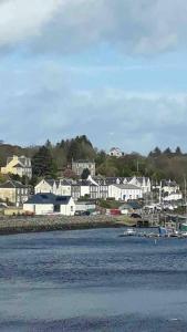 a town with white houses and boats in the water at Tarbert large, bright, 4 bedroom flat with harbour views in Tarbert
