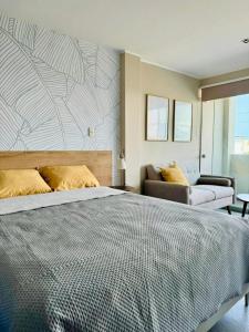 a bedroom with a large bed and a couch at Almar Punta Hermosa in Punta Hermosa