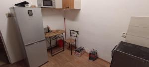 a kitchen with a refrigerator and a table and a microwave at Wilson-Consulting in Nitra