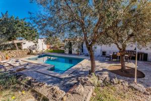 una piscina en un patio con mesa y árboles en Villa Can Abrines, en Lloseta