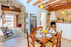 cocina y comedor con mesa de madera y sillas en Villa Can Abrines, en Lloseta