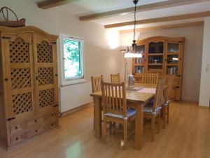 a dining room with a wooden table and chairs at Ferienhaus Naturliebe 6000qm Parkgarten am Wald, umzäunt, Kamin, Sauna in Laubach