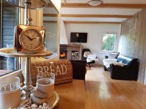 a living room with a clock on a table at Ferienhaus Naturliebe 6000qm Parkgarten am Wald, umzäunt, Kamin, Sauna in Laubach